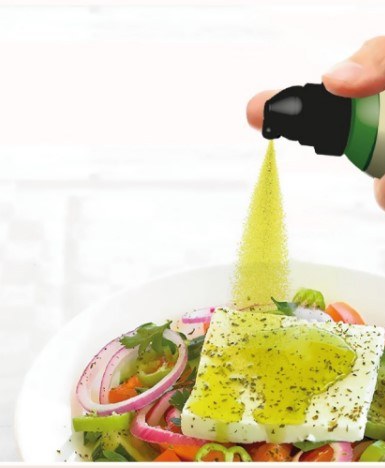 Spray à l'huile d'olive utilisé sur une salade fraîche